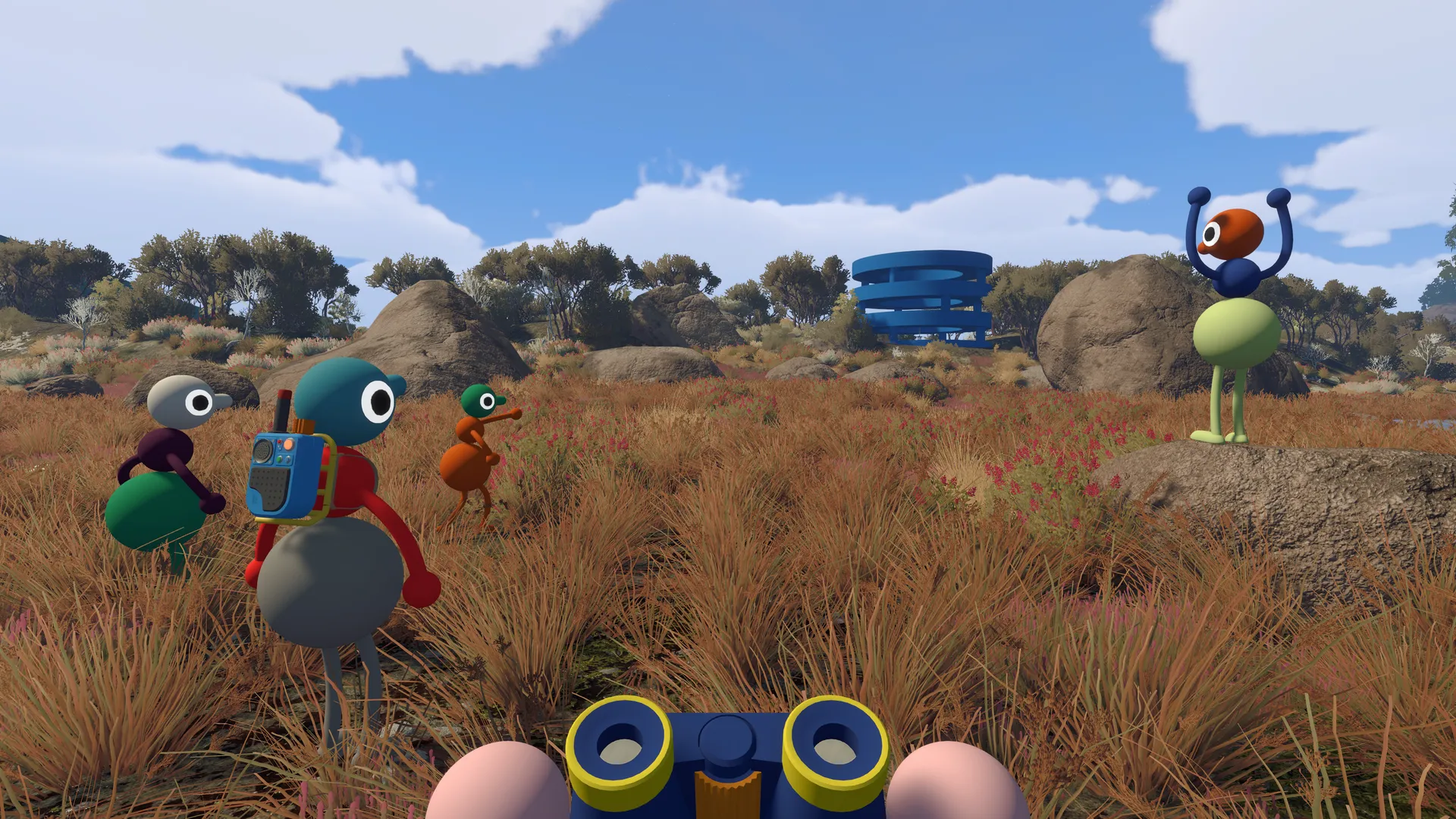 Binoculars in the foreground as friends gather in a grassy clearing.